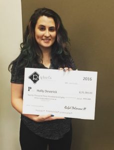 Holly Devorick holding her scholarship at Raphael's.