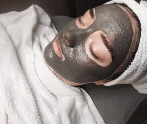 A woman with a face mask in a spa environment.