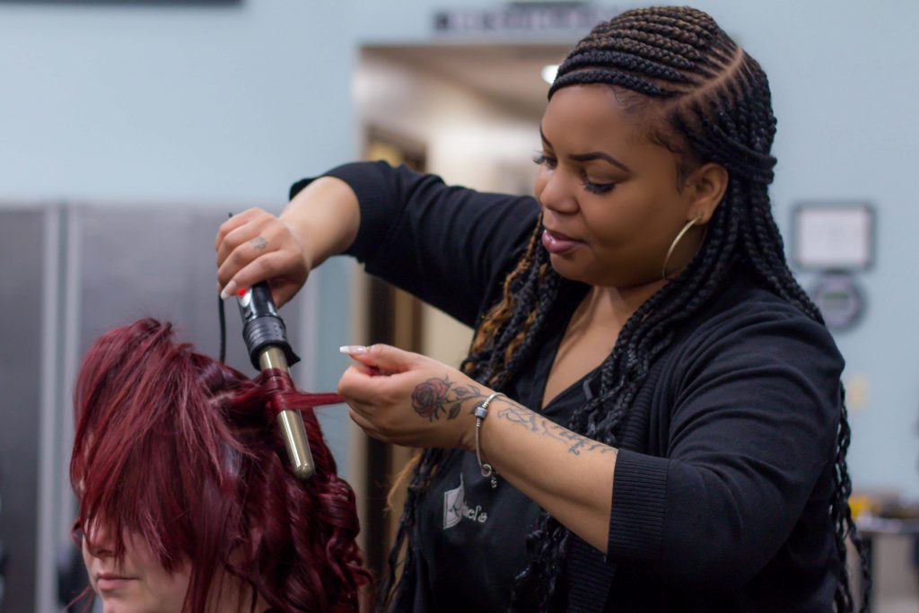Woman styling another woman's red hair